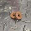 MechSirenBrake - Ridgeway Leatherworks Two small brown circular discs with a central hole stacked on a textured metal diamond plate.