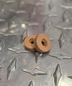 Two small brown circular discs with a central hole stacked on a textured metal diamond plate.